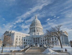 Wisconsin State Capitol building with snow on the lawn and blue skies